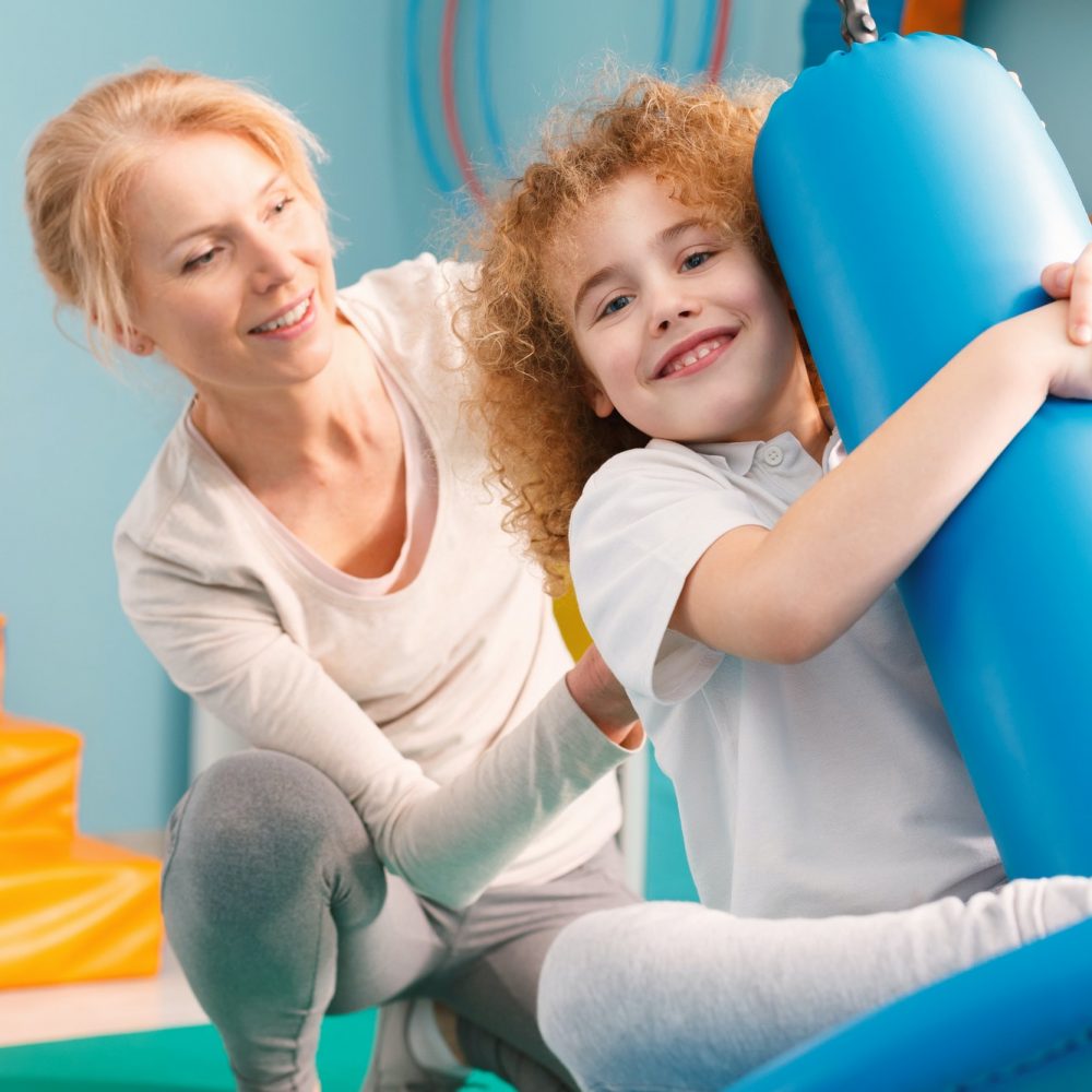 Therapist watching a boy on disc swing